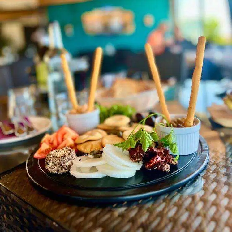 A traditional Maltese platter featuring galletti, sun-dried tomatoes, olives, and dips served at a local restaurant in Qala.